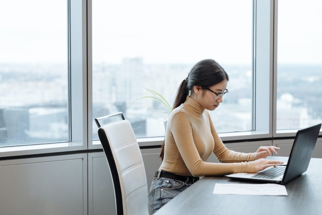 Woman Sitting at Desk on Computer