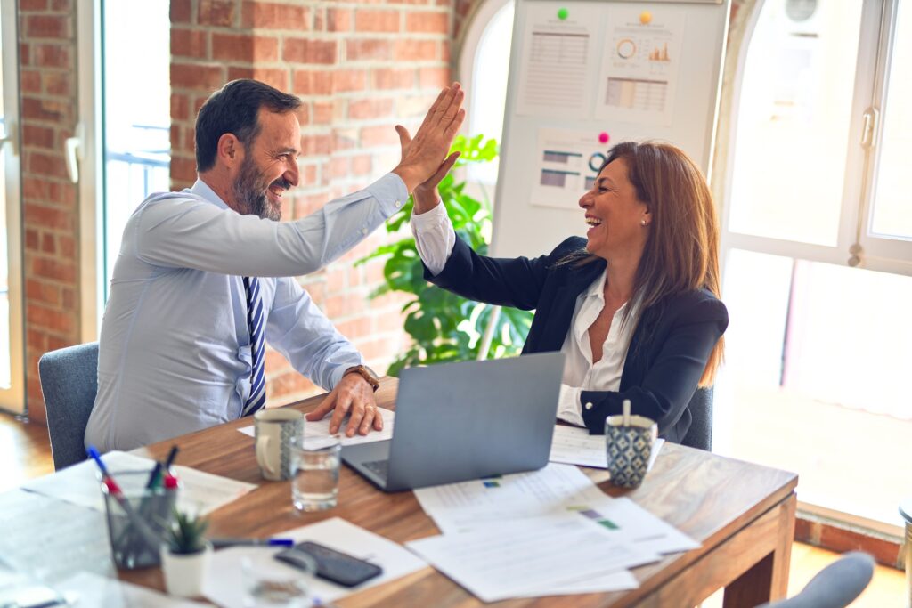 man and woman high fiving at work