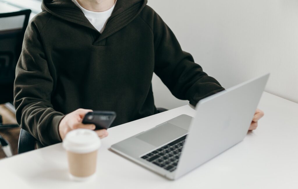 Work-life balance man on the computer and on his phone with a coffee