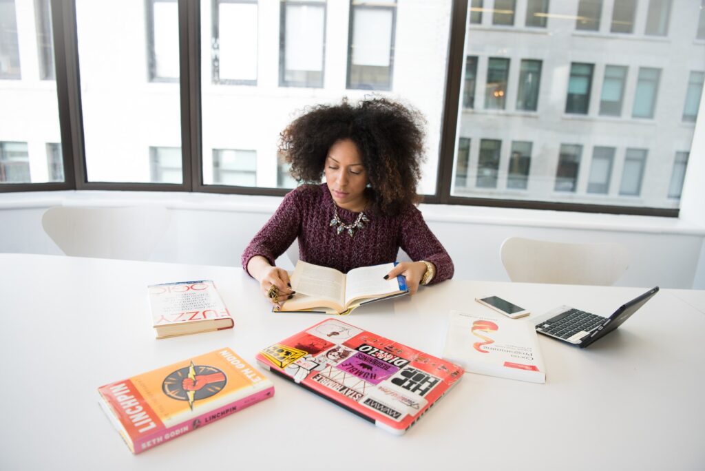 Woman Reading a few books at a desk