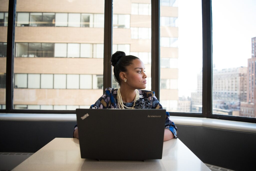 A woman looking outside while on the computer career change