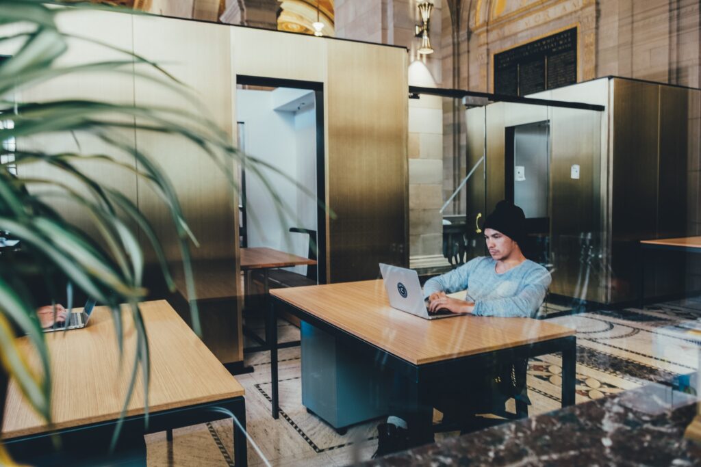 Man Sitting at a table in a coffee shop on a computer