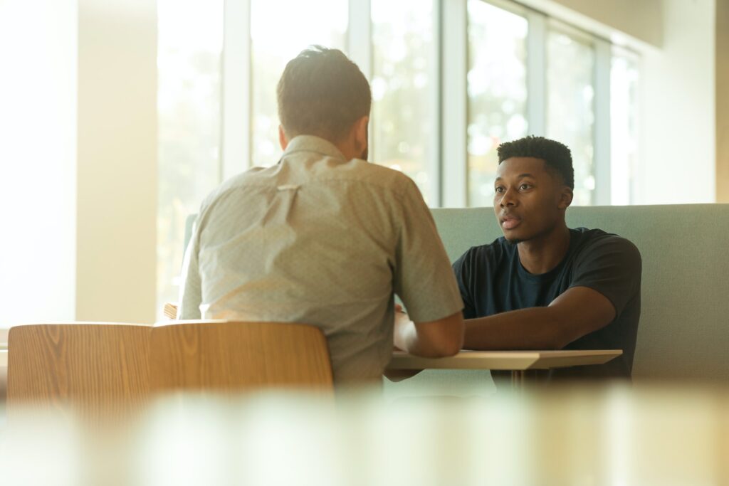 Two guys talking at a table