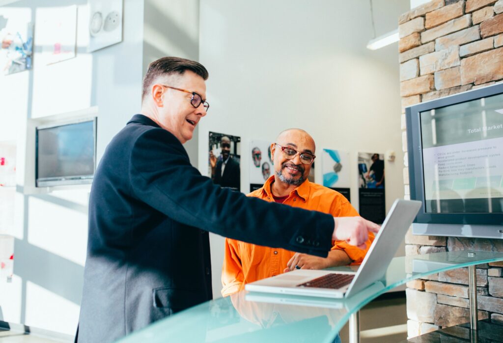 two men working on a laptop together