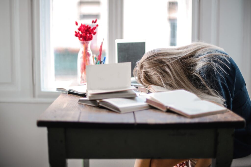 Woman Exhausted Leaning on a Desk