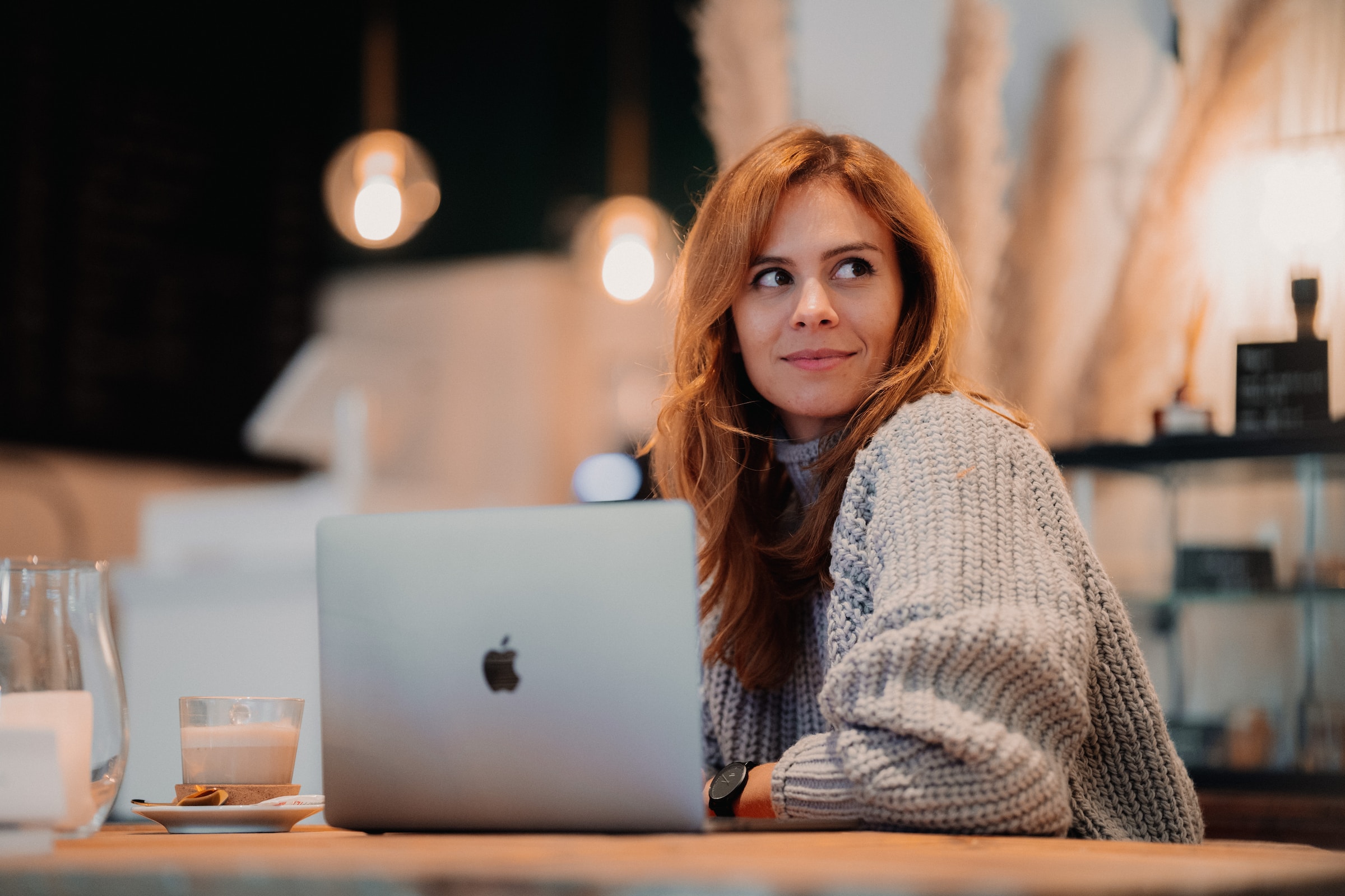 woman sitting at table working happy smiling