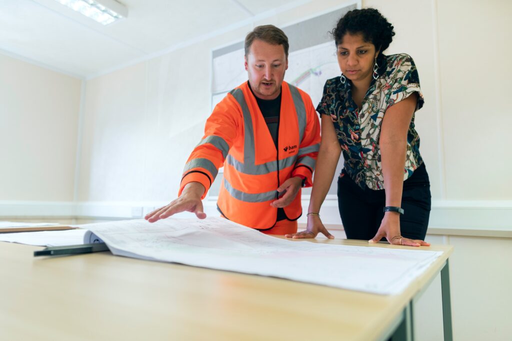 Man and woman looking at a paper construction plans job and career