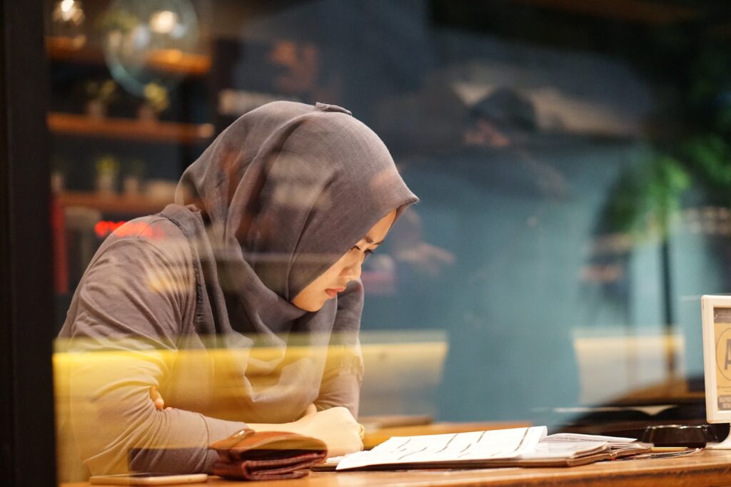 Young Lady with a hijab at a coffee shop cafe working