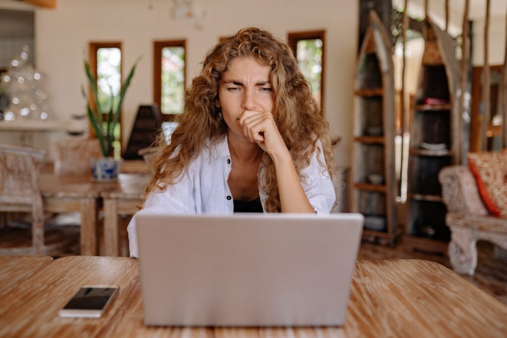 woman sitting at computer thinking ai resume builder