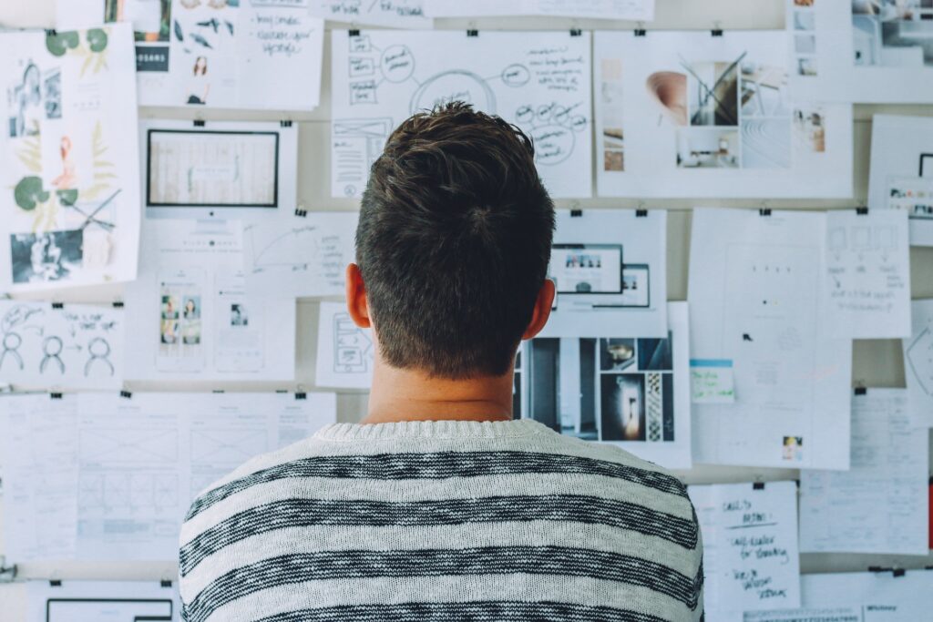 Man staring at a wall full of papers