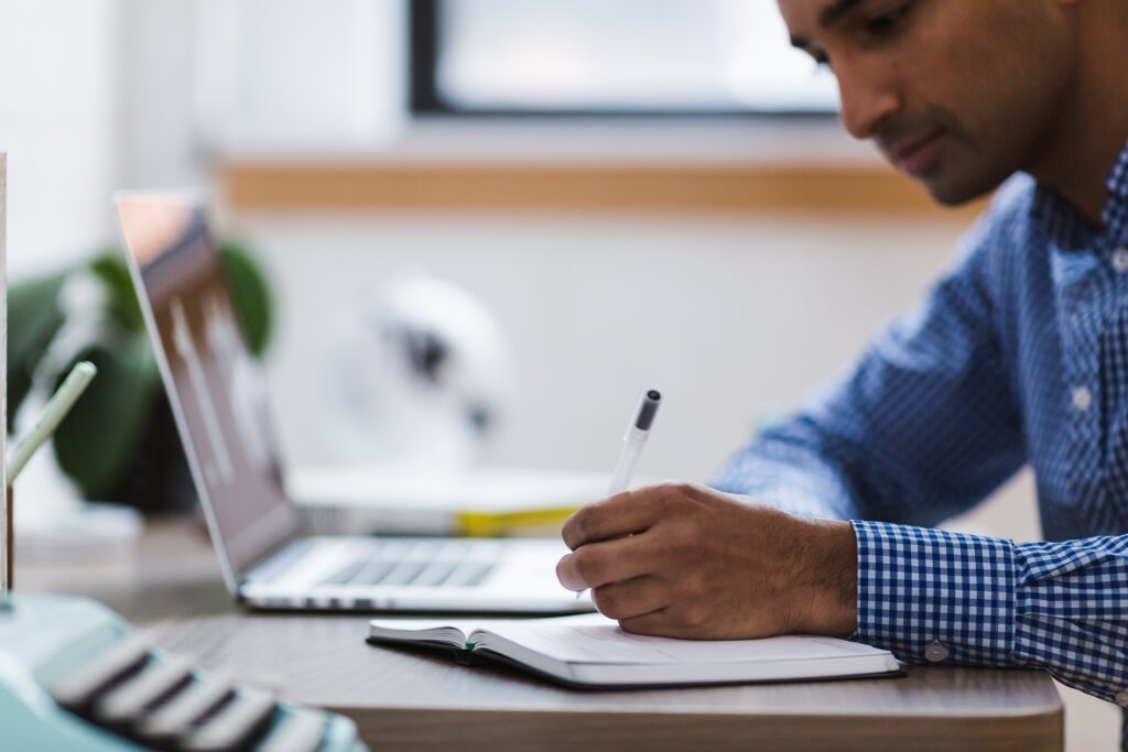 man writing in a notebook