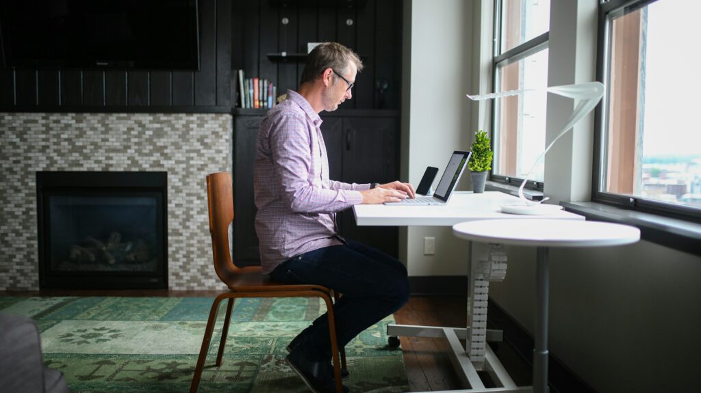man sitting at a desk with a laptop working